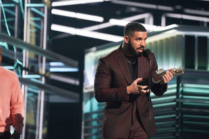 Drake onstage accepting an award.
