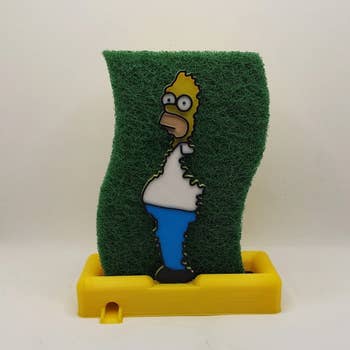a sponge holder with homer simpson holding a green sponge