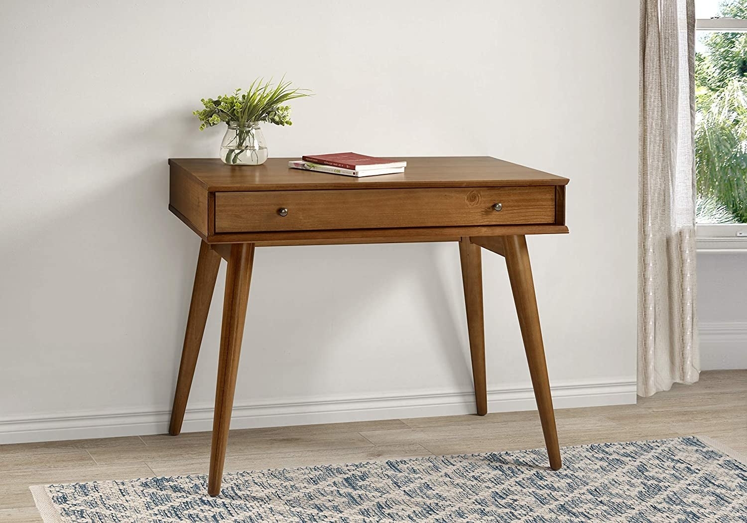 the walnut desk against a white wall