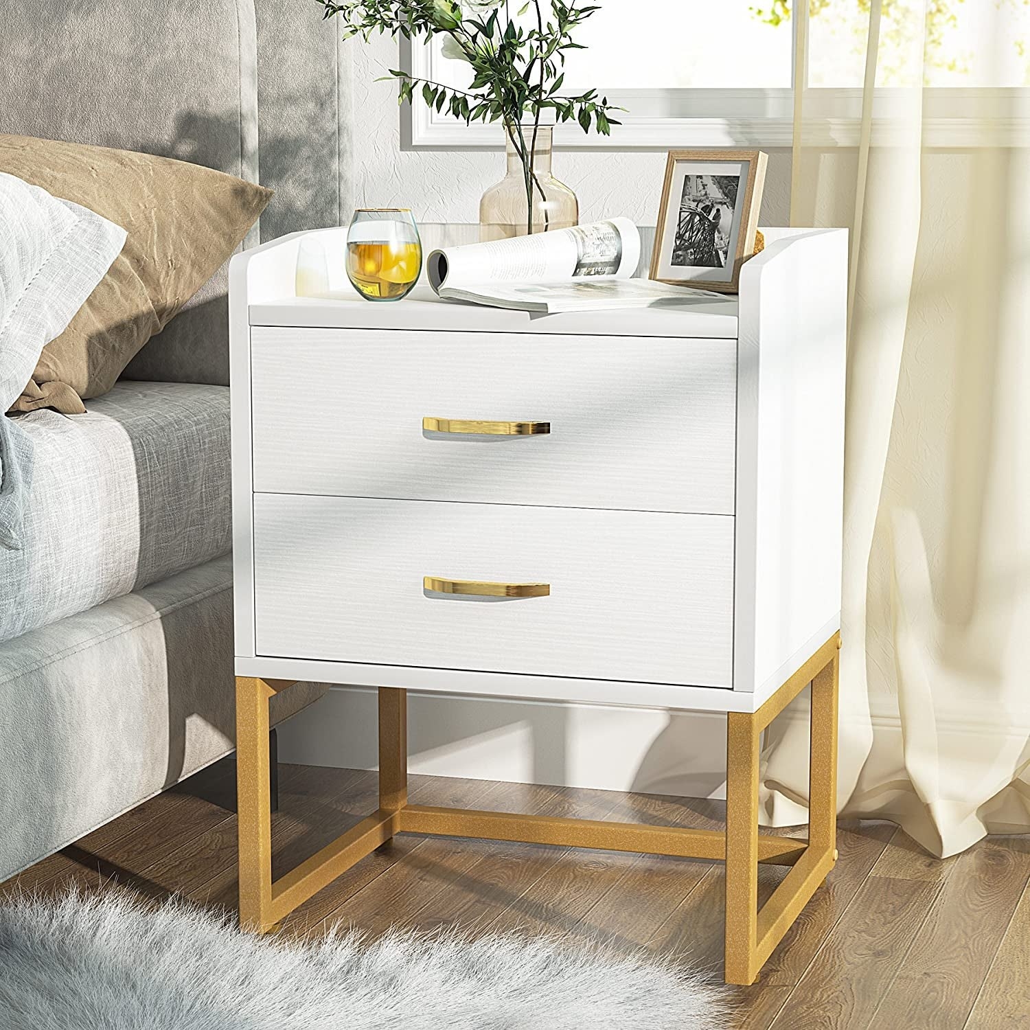 the white and gold nightstand next to a bed
