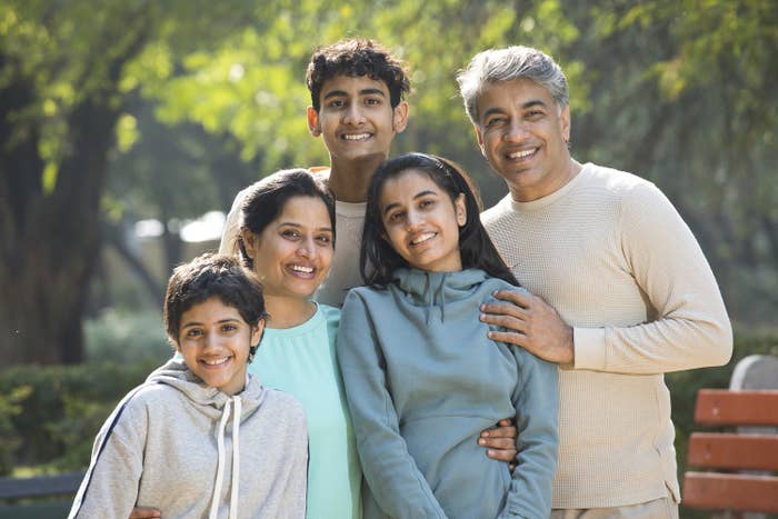 A family poses and smiles at the park