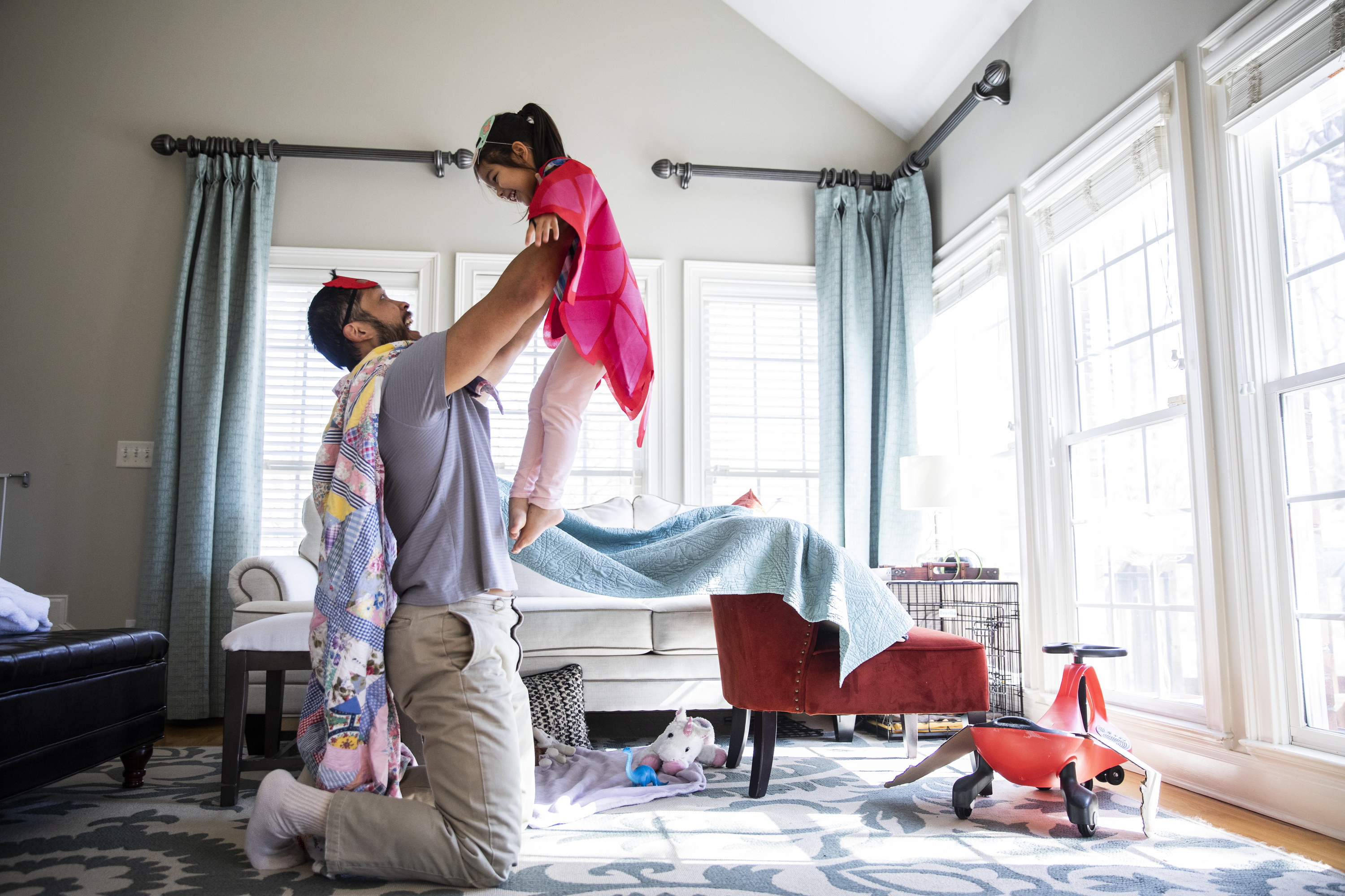 A dad and his daughter play as superheroes in their home