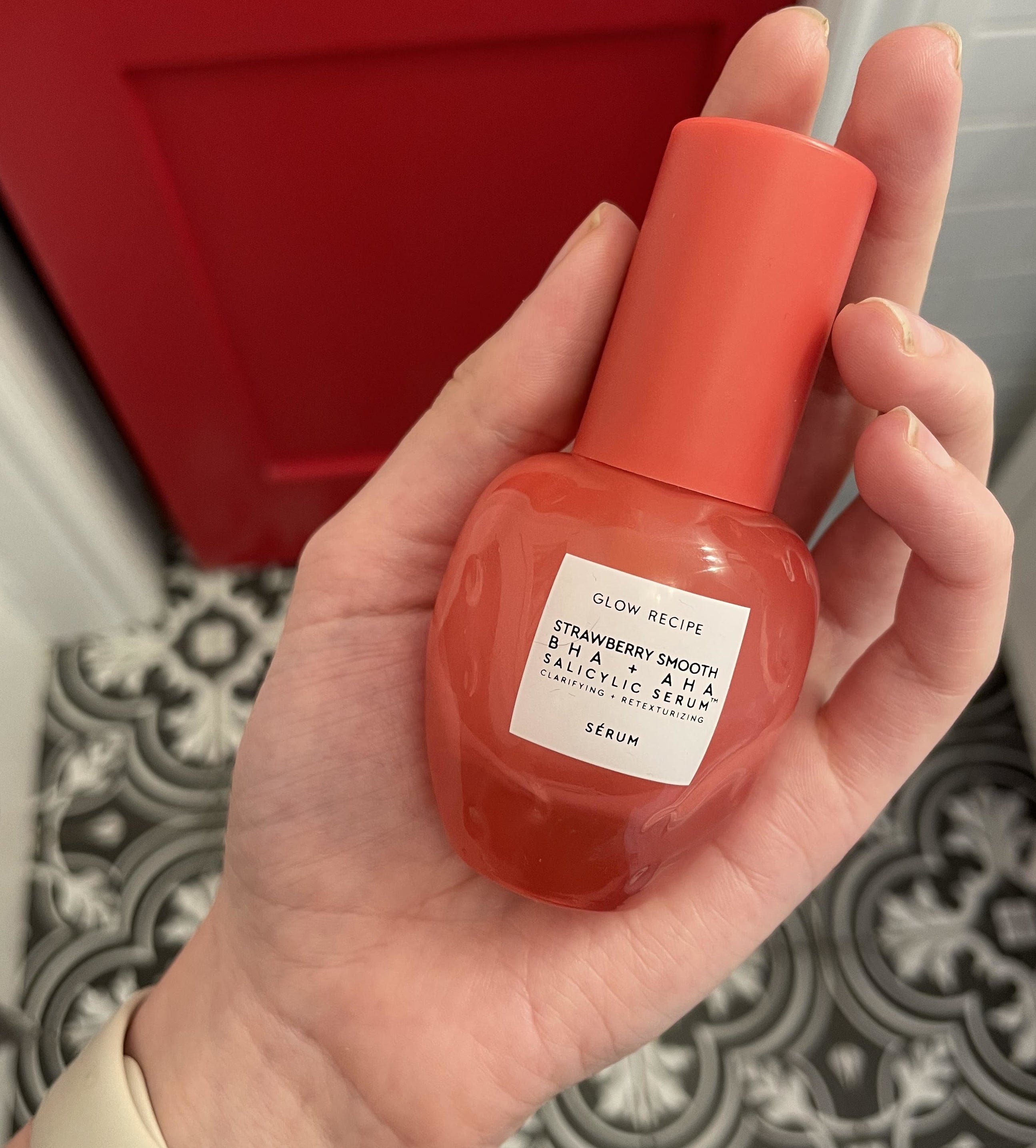 A person holding the bottle of serum