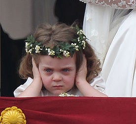 A close-up of the very angry little girl still holding her hands over her ears