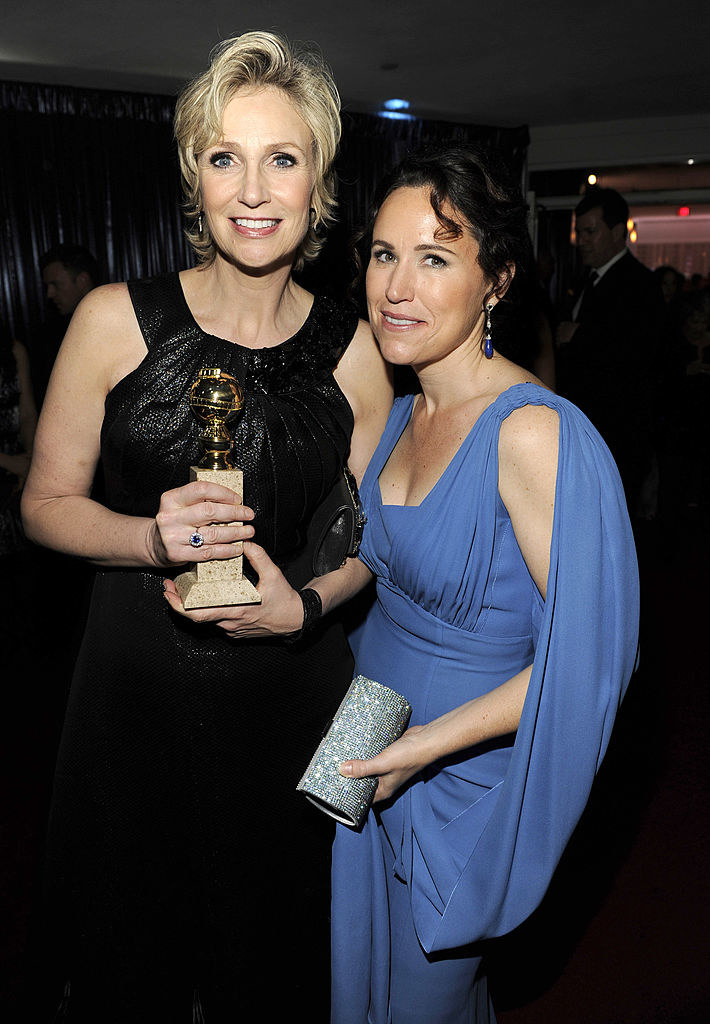Jane holding her award with Lara beside her