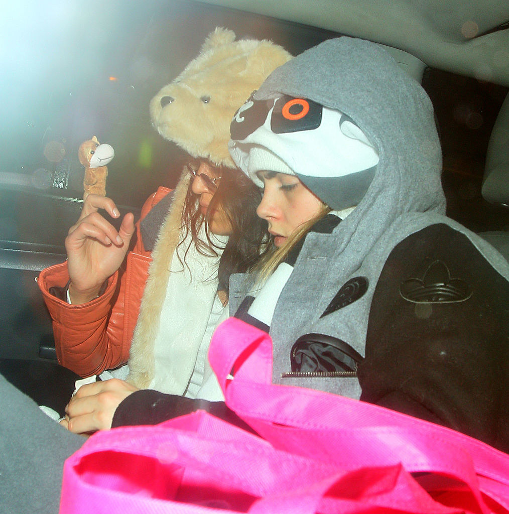 the two wearing animal hats in the back of a car