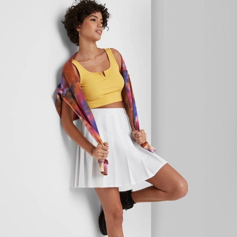 model wearing the white pleated tennis skirt