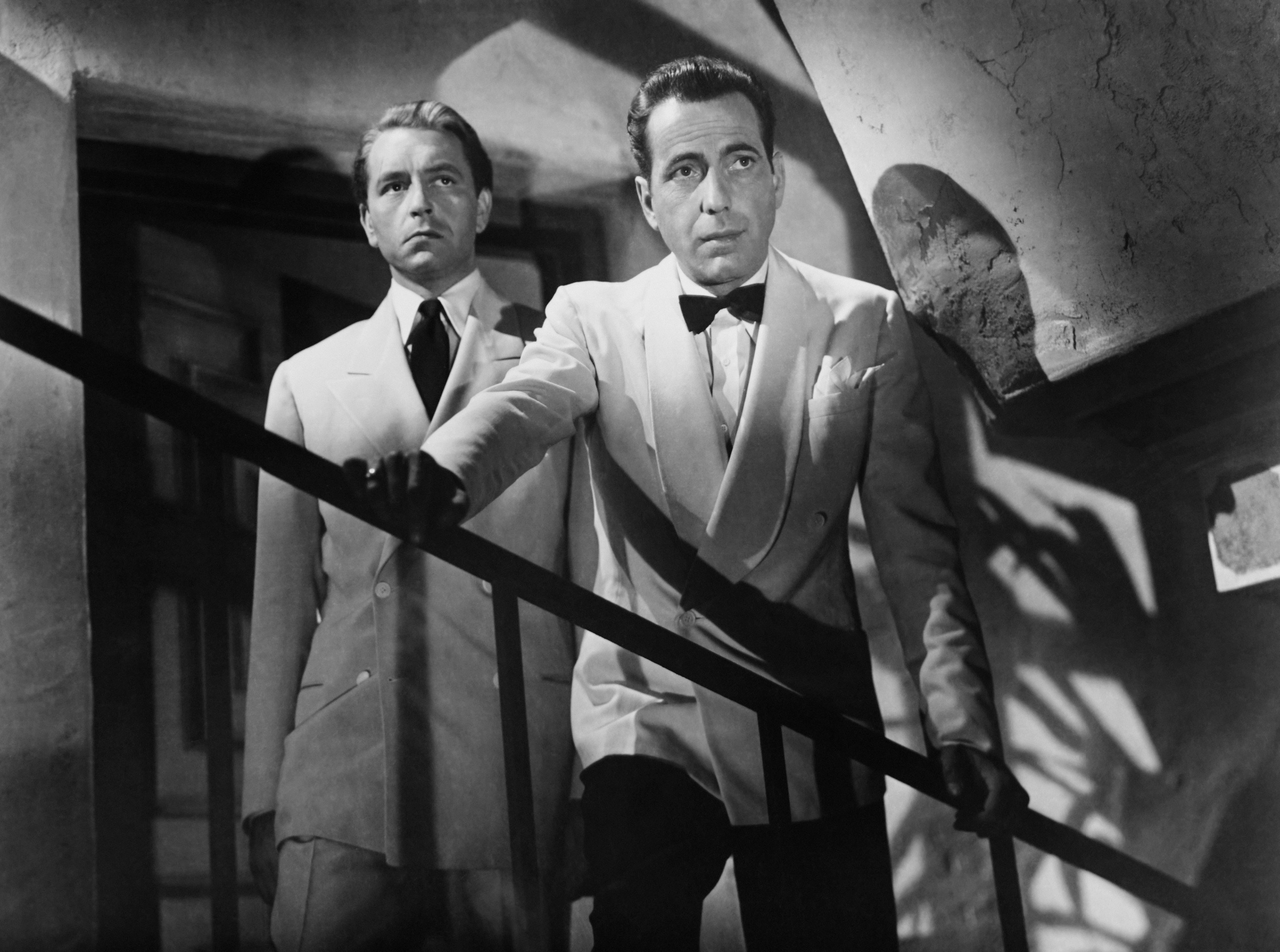 Humphrey Bogart standing on a staircase, looking down