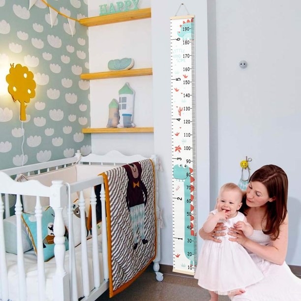 Women holding baby by growth chart