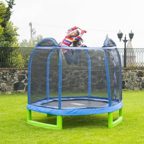 child jumping on trampoline outside