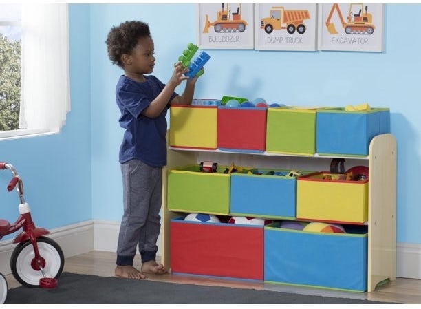 child putting toys away in the organizer