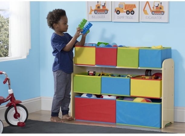 Little boy putting his toy away in orgainzer