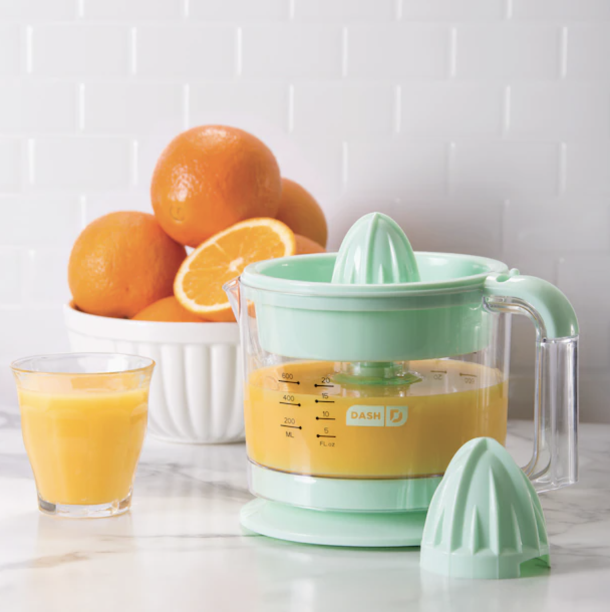 a dual headed electrical citrus reamer filled with fresh pressed orange juice