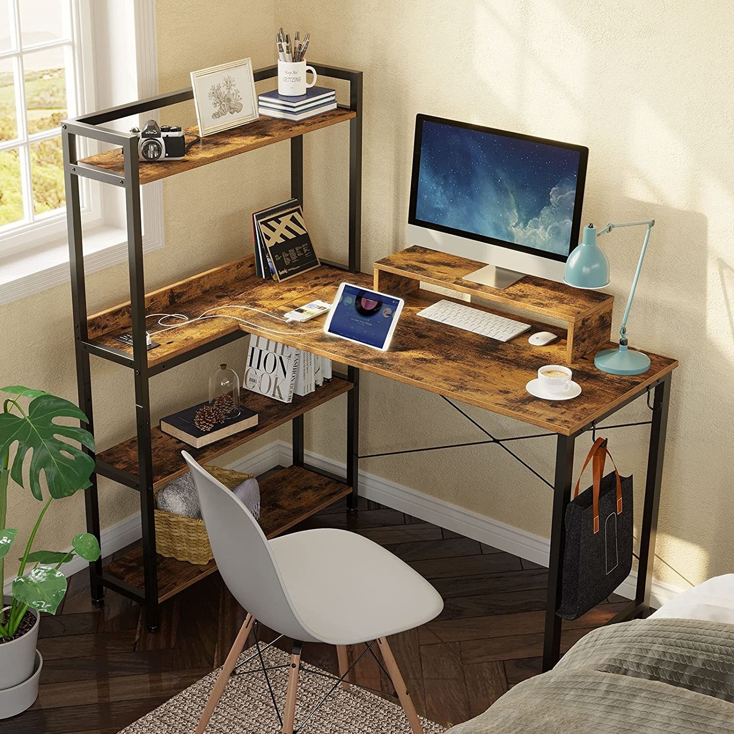 The desk in a bedroom with a bunch of gadgets on it