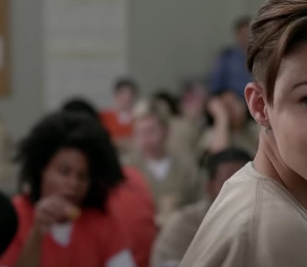 Ruby Rose with a short haircut in a prison uniform.