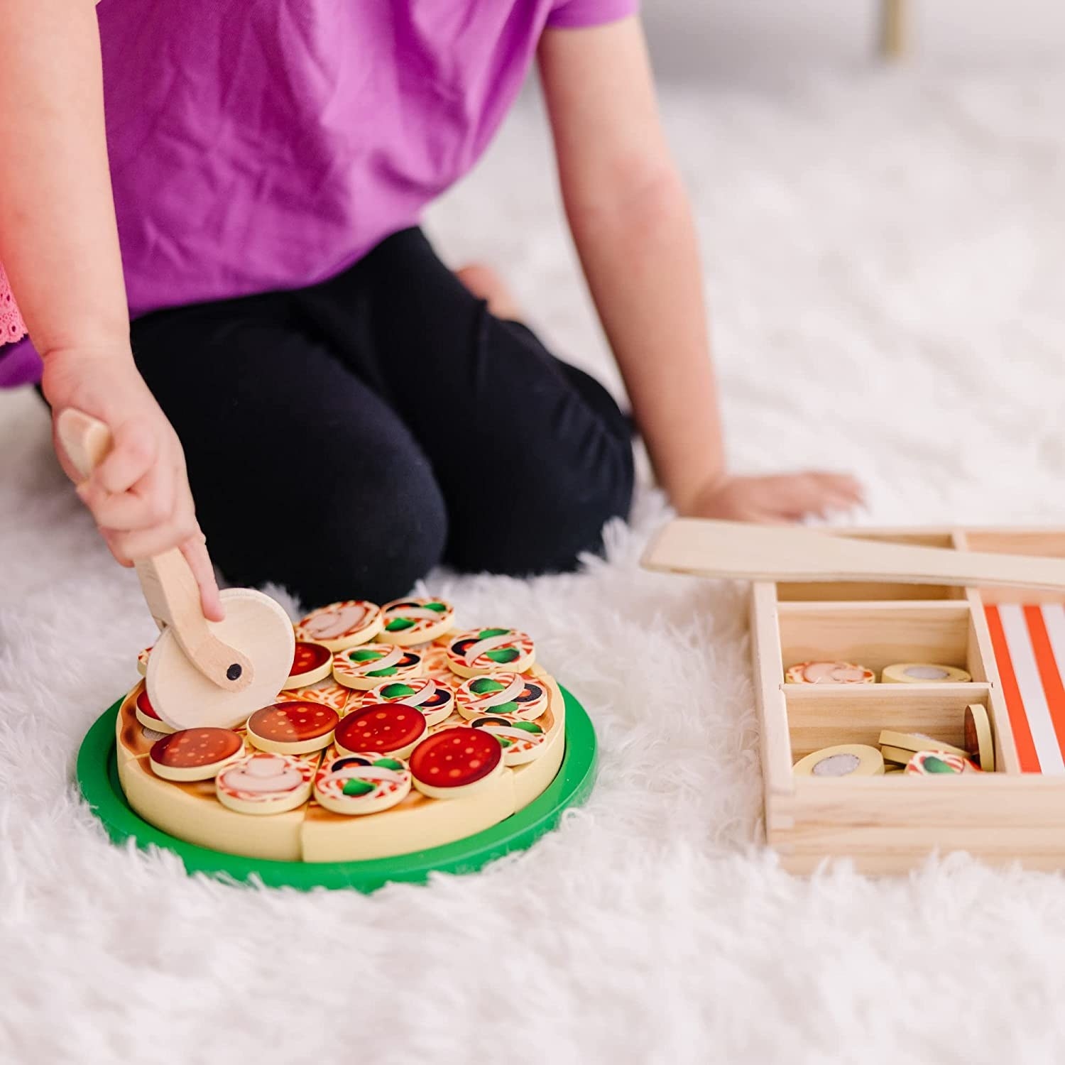 A kid playing with the pizzeria set