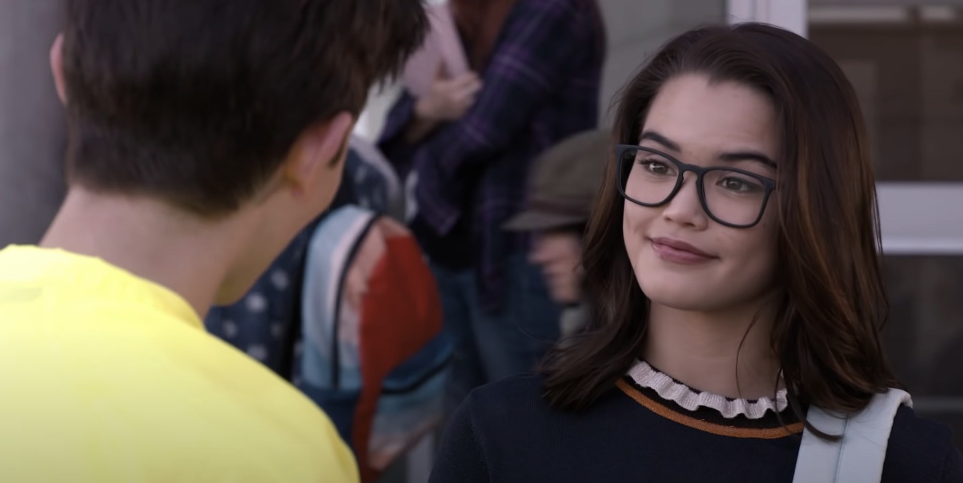 Paris Berelc in glasses talks to a boy off-screen