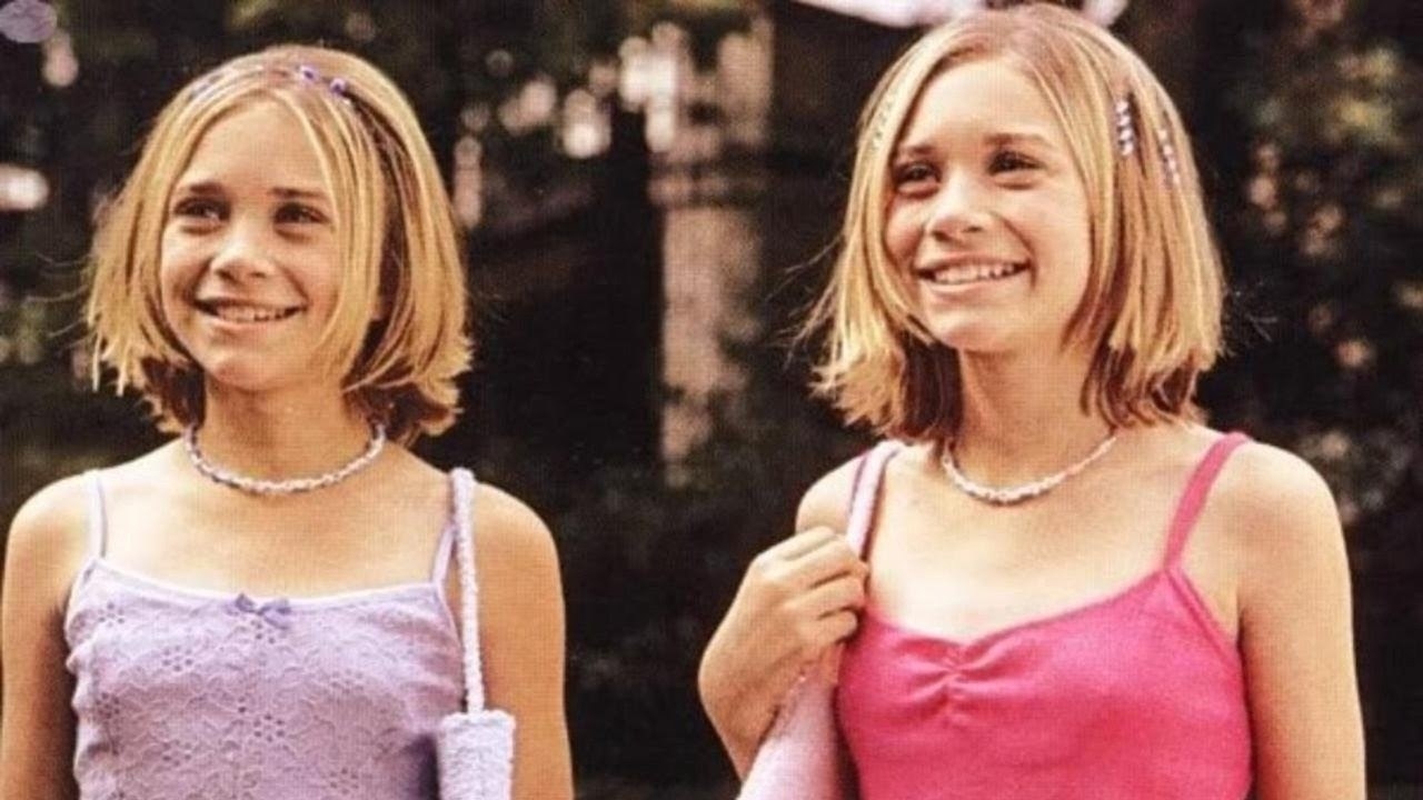 Mary Kate and Ashley stand together smiling