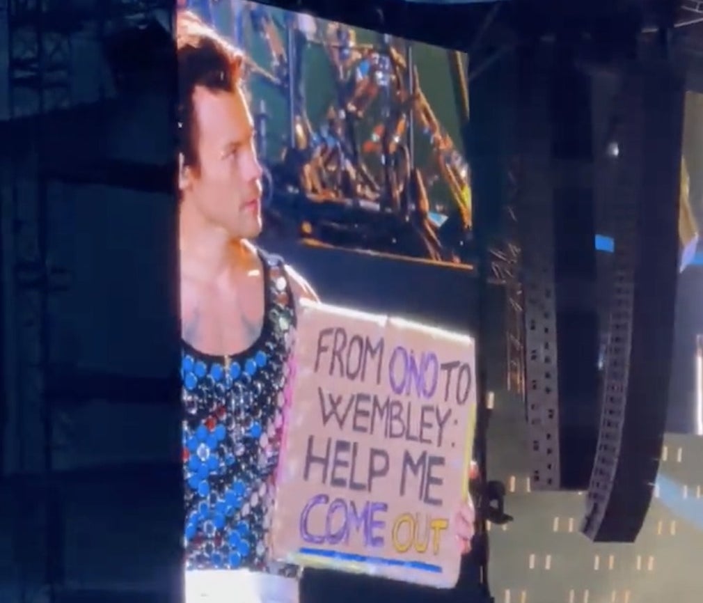 Harry holds up the sign on stage