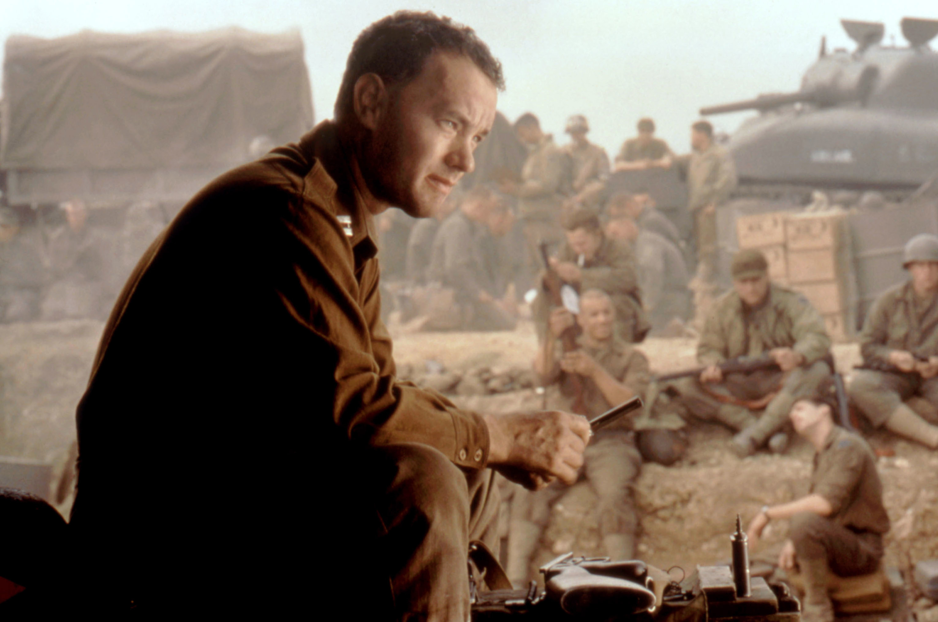 A man at war sits around with his fellow soldiers