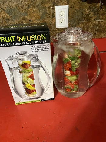 Pitcher filled with fresh fruit and water in it