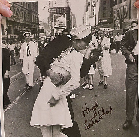 sailor kissing a woman on a busy street