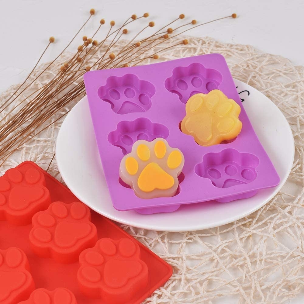the mould with two paw shaped treats popped out of it on a plate