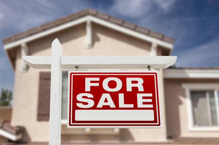A &quot;For Sale&quot; sign in front of a house