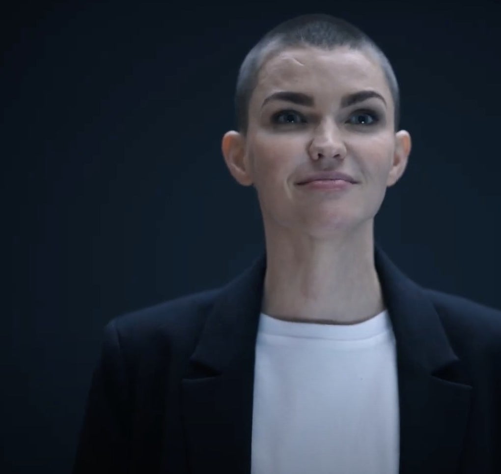 Ruby Rose with a buzz-cut, wearing a dark black blazer and white t-shirt.