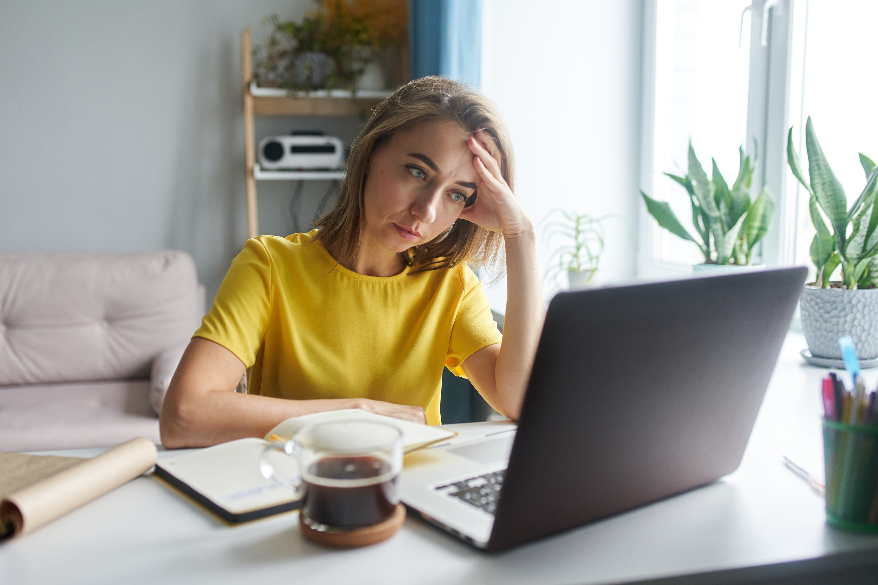 A woman looks stressed out while she stares at her laptop