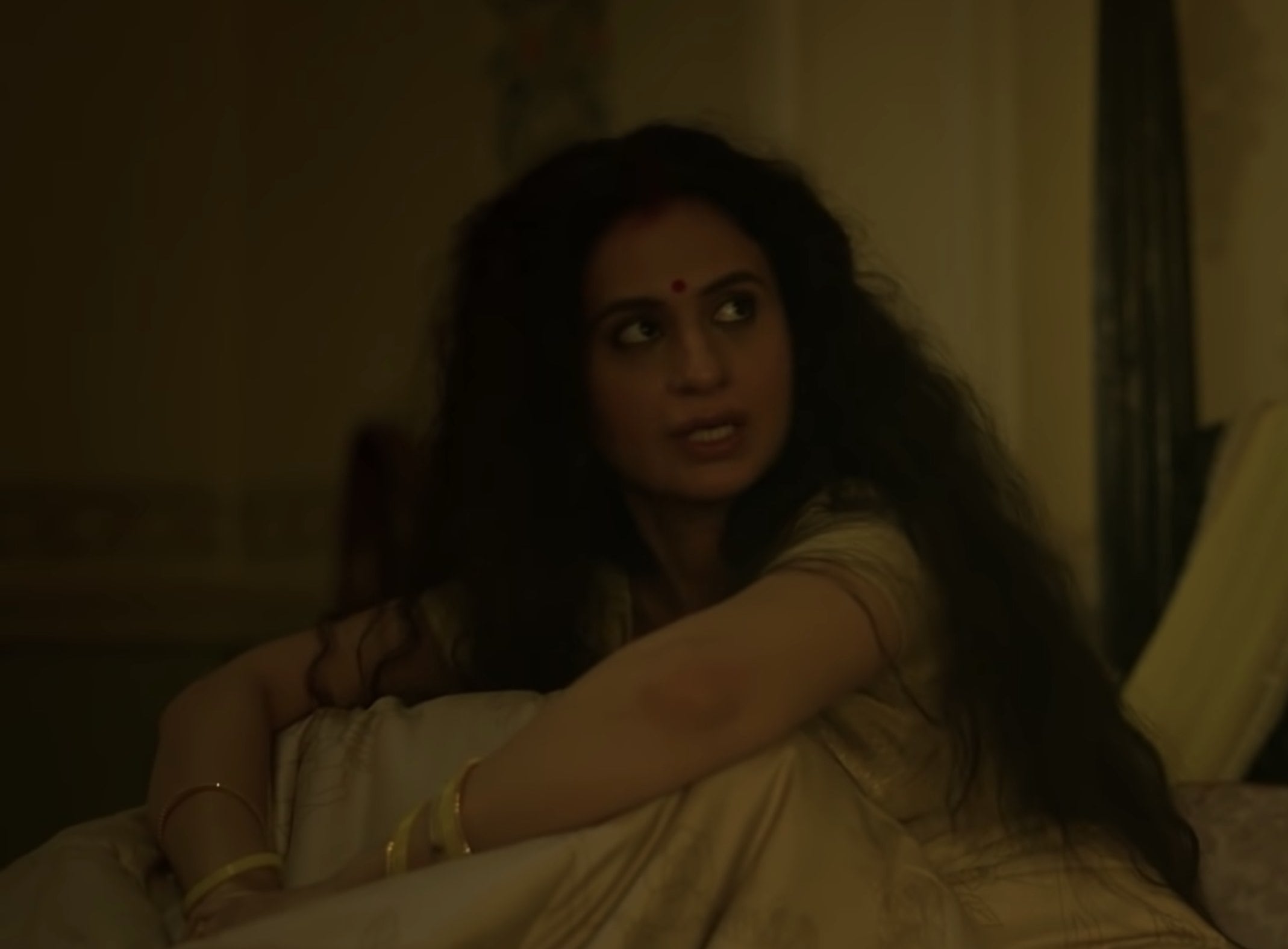 Rasika Dugal sitting on a bed and talking