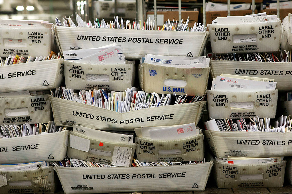 A stack of envelopes labeled United States Postal Service
