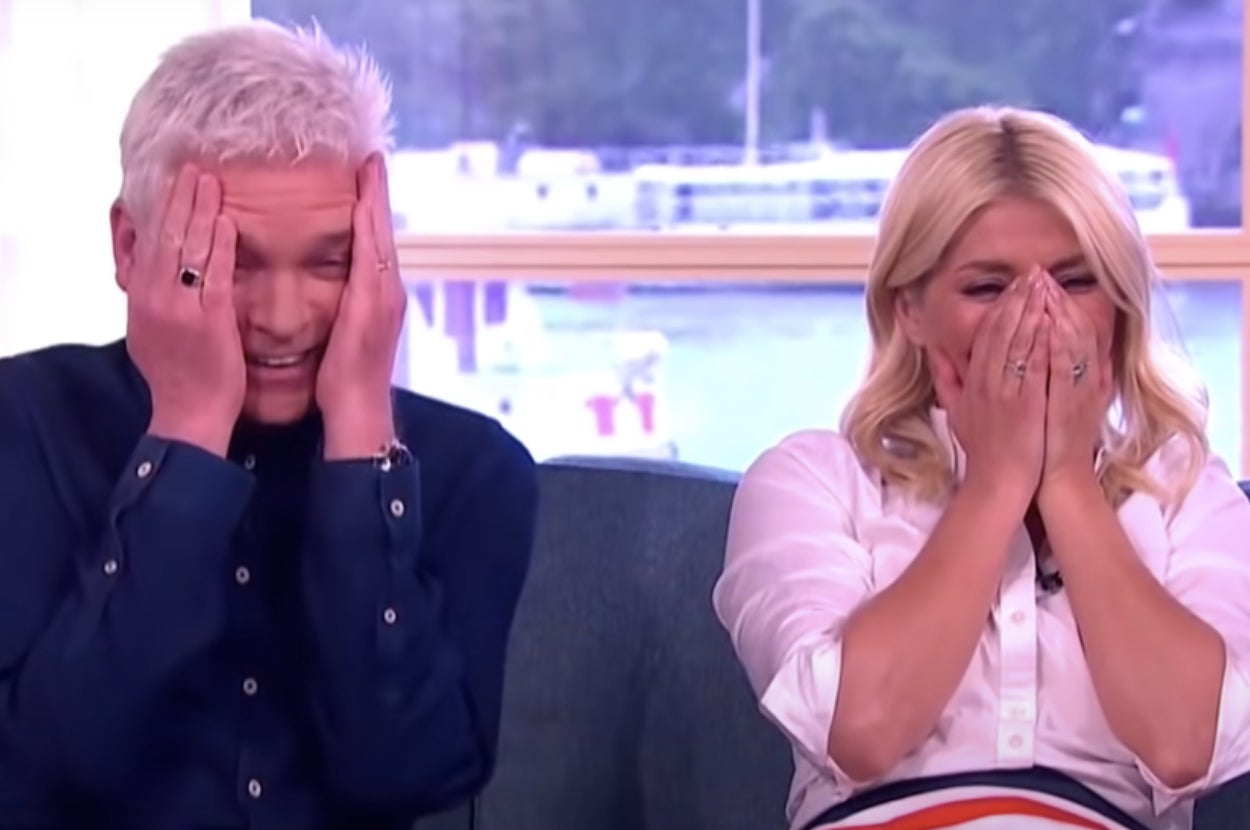 A man and a woman laughing and cringing