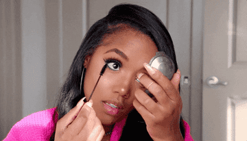 A woman applying eye makeup