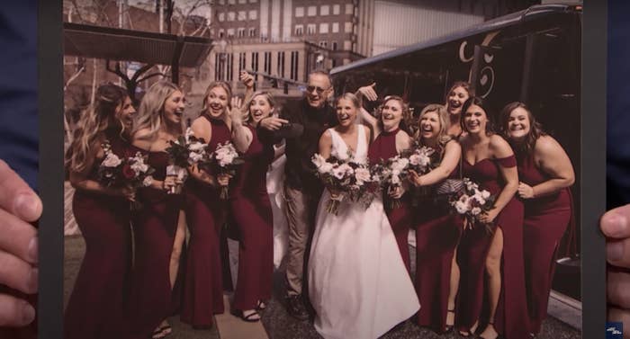 Tom poses with a bride and group of bridesmaids in front of a party bus