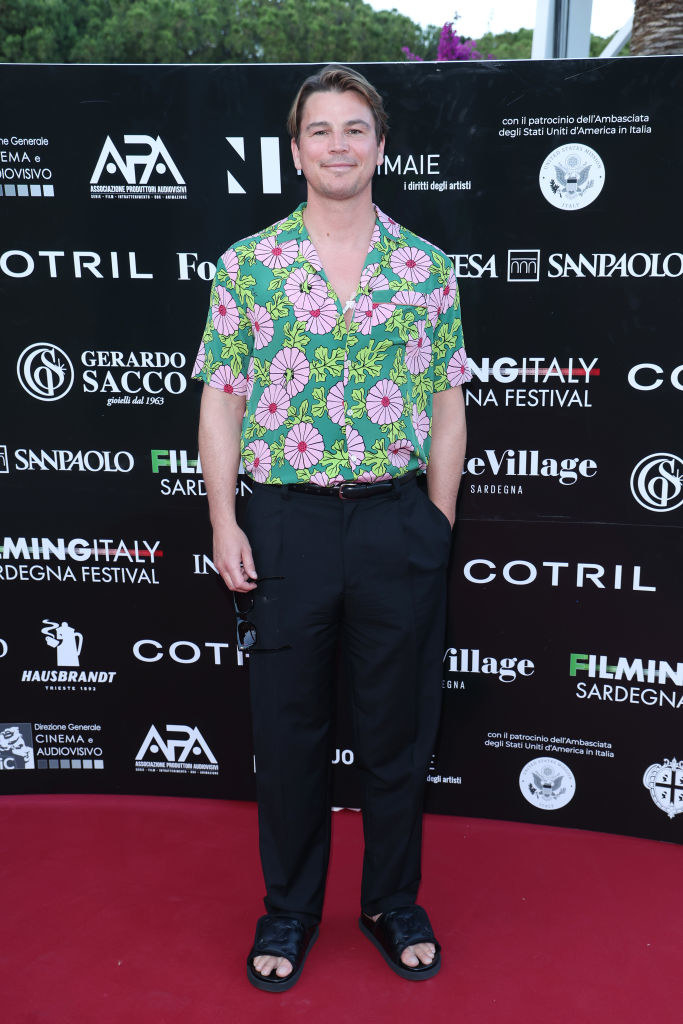 On the red carpet wearing a flowery short-sleeved shirt and sandals