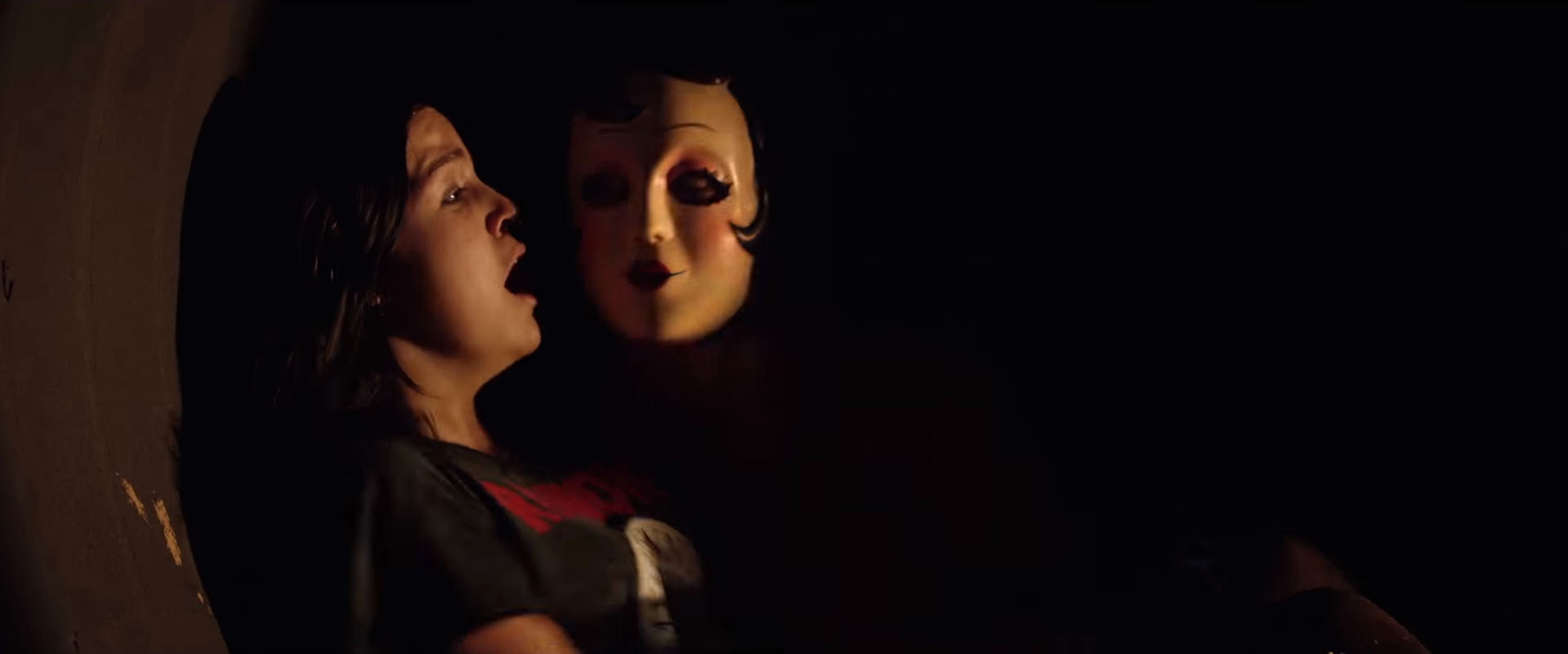 The Strangers: Prey at Night: A woman in a mask sits beside a terrified woman