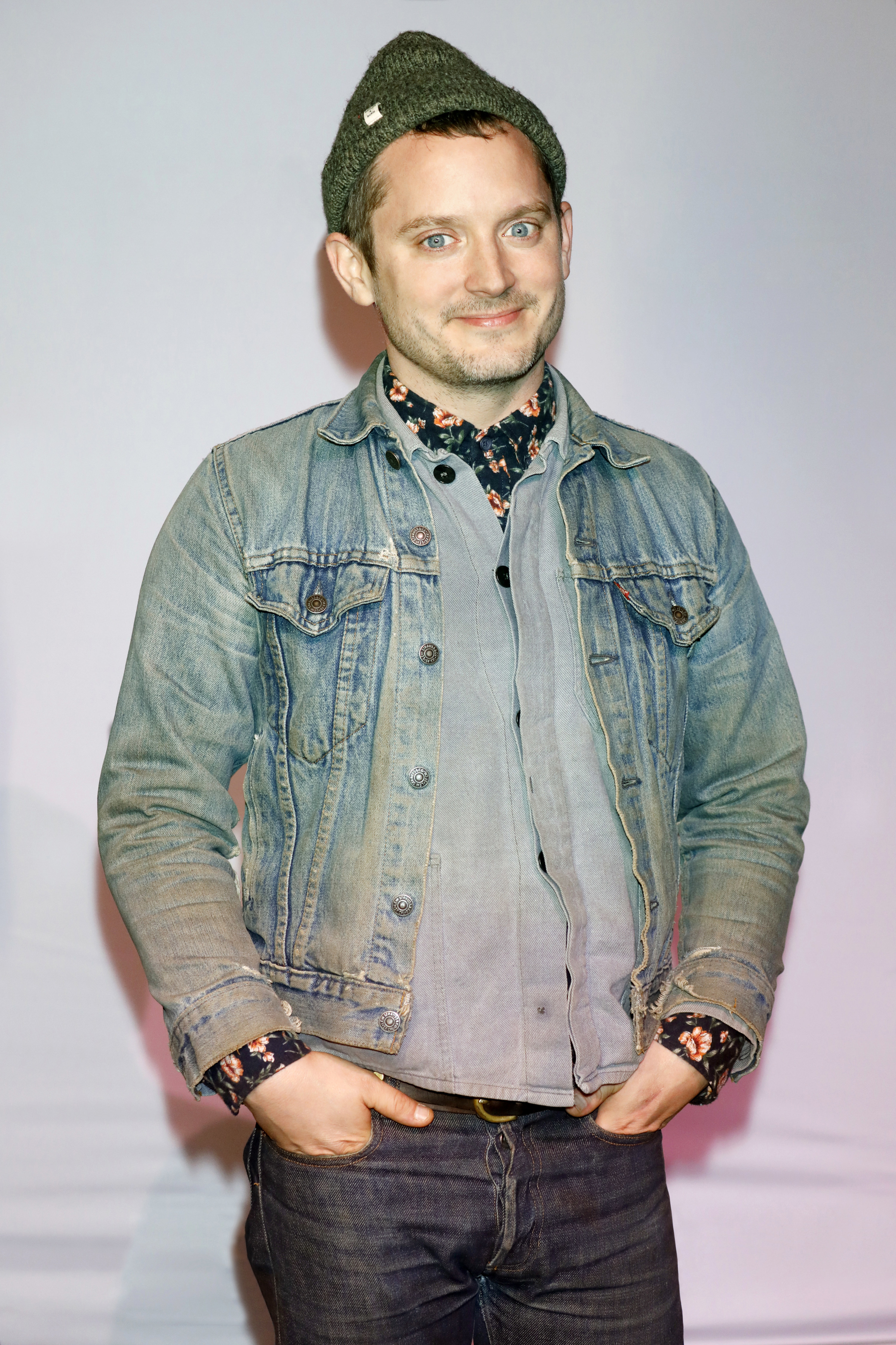 Wearing a denim jacket and jeans and hands in jeans pockets