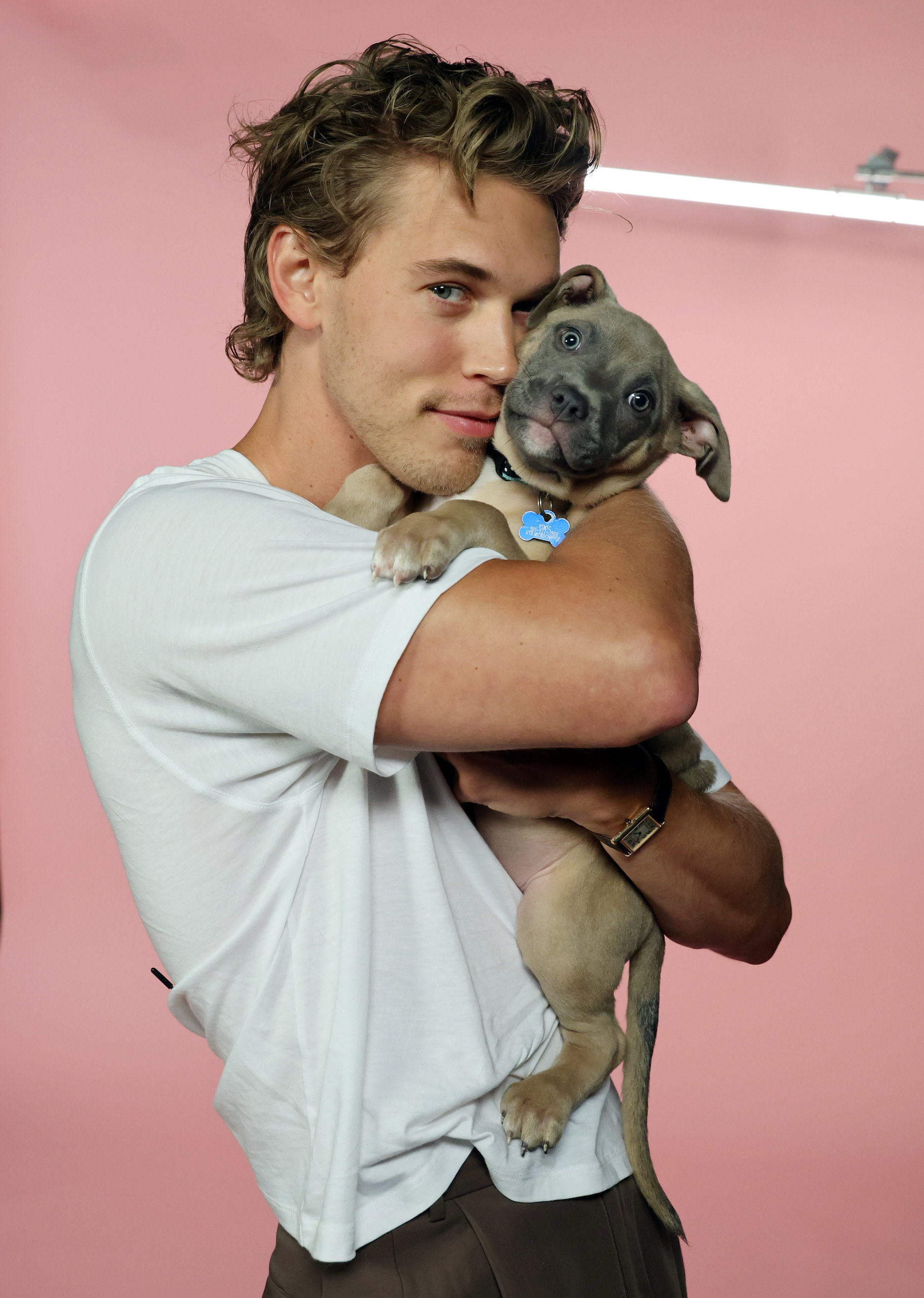 Austin cuddling one of the puppies, touch their cheeks to each other