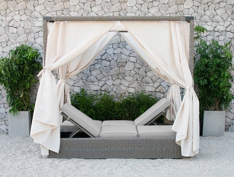 beige reclining double chaise with a cream colored canopy