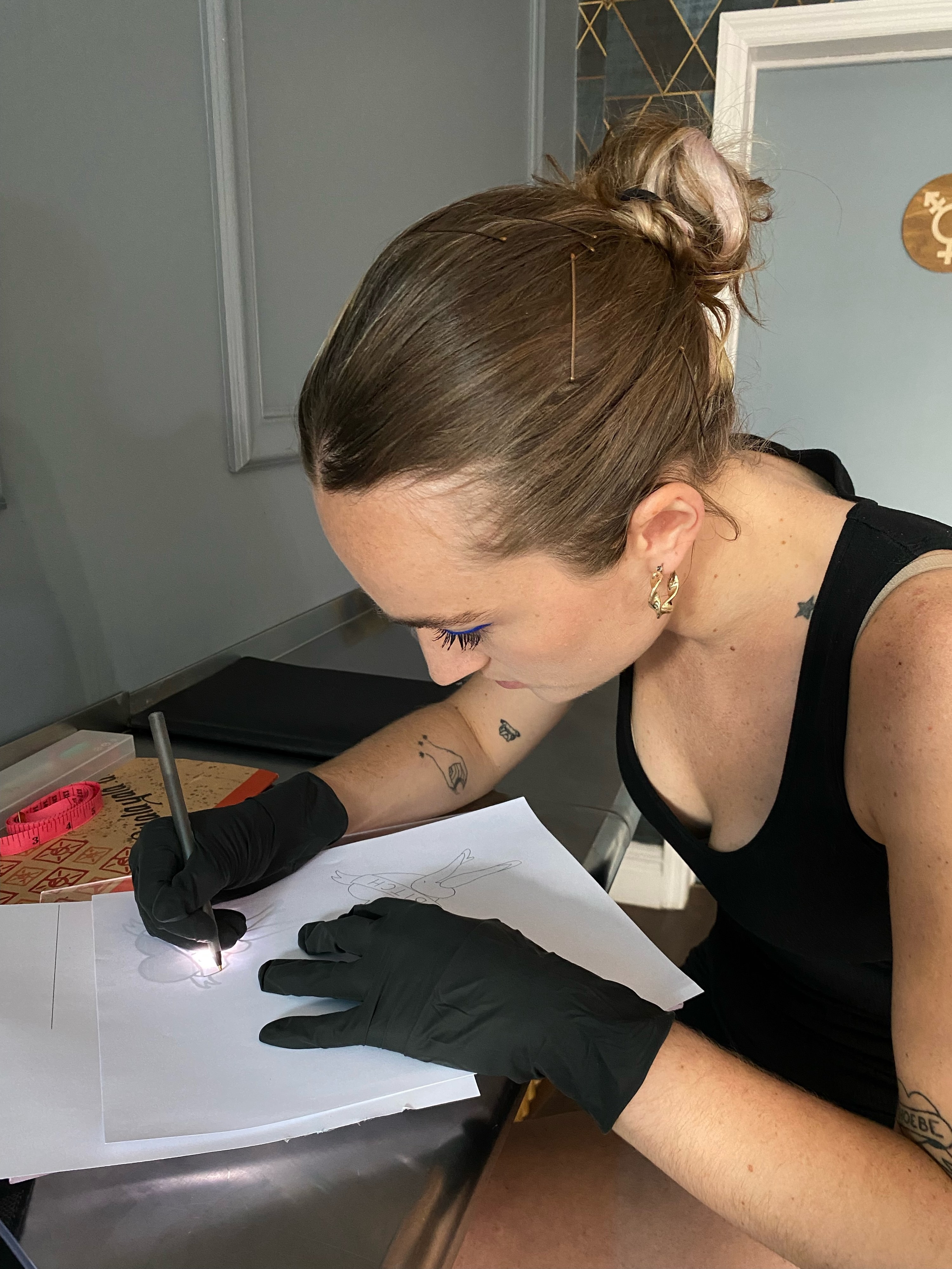 A tattoo apprentice drawing a tattoo