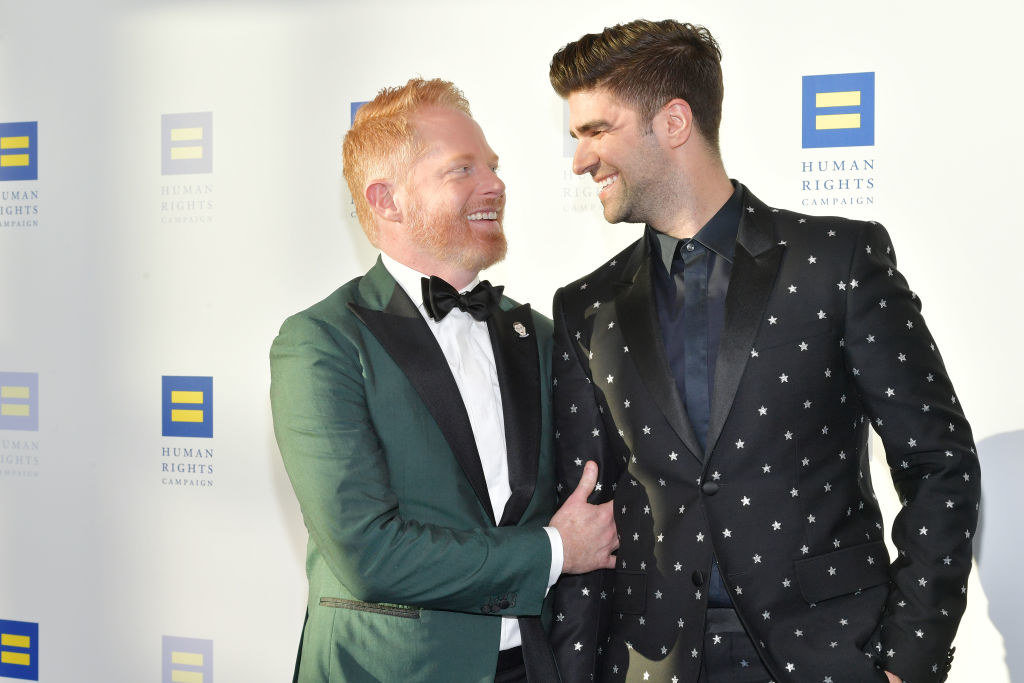 Jesse Tyler Ferguson and his husband looking at each other and smiling