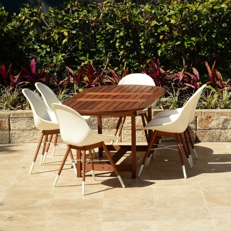 brown and white six-person dining table and chairs set up outside