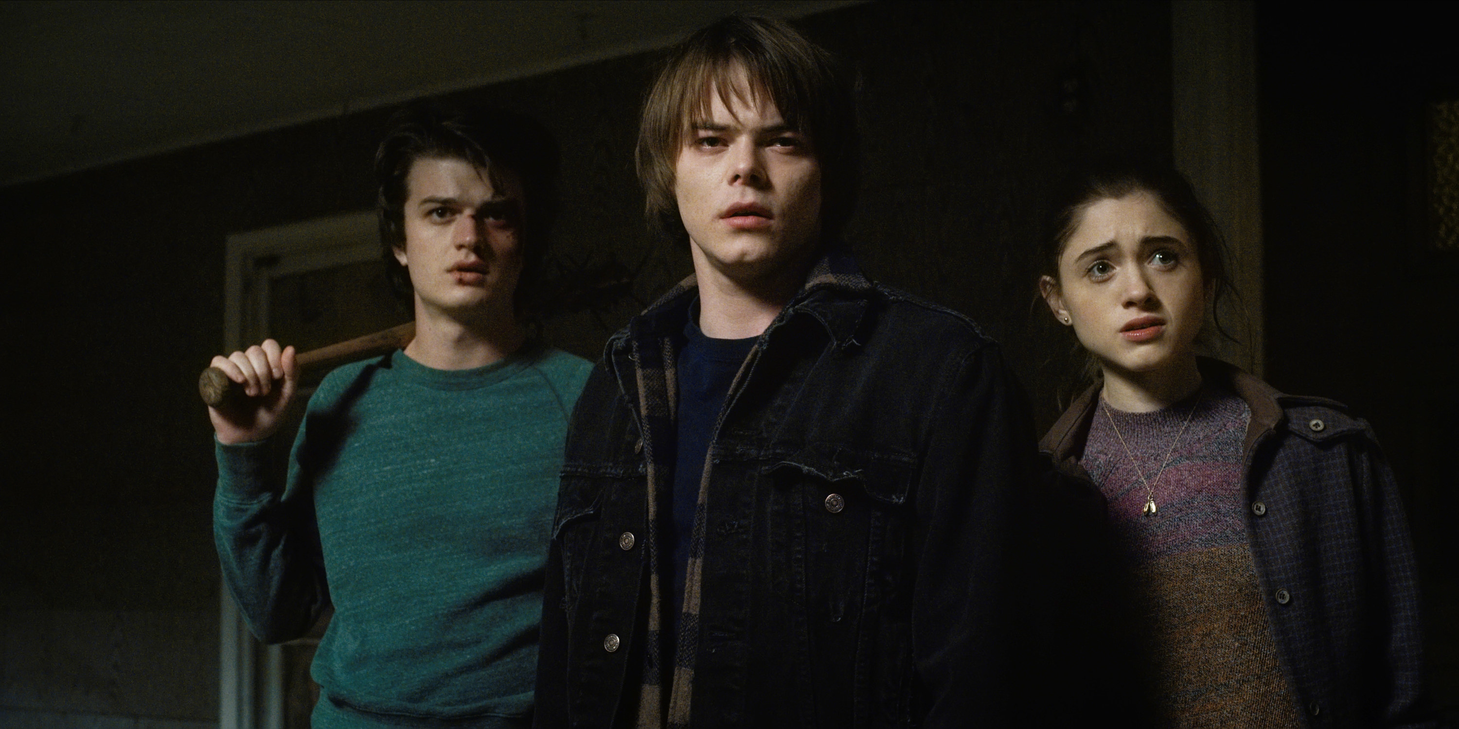 three of the characters standing in a dark room