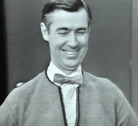 Mister Rogers smiling and talking with hands showing the middle finger