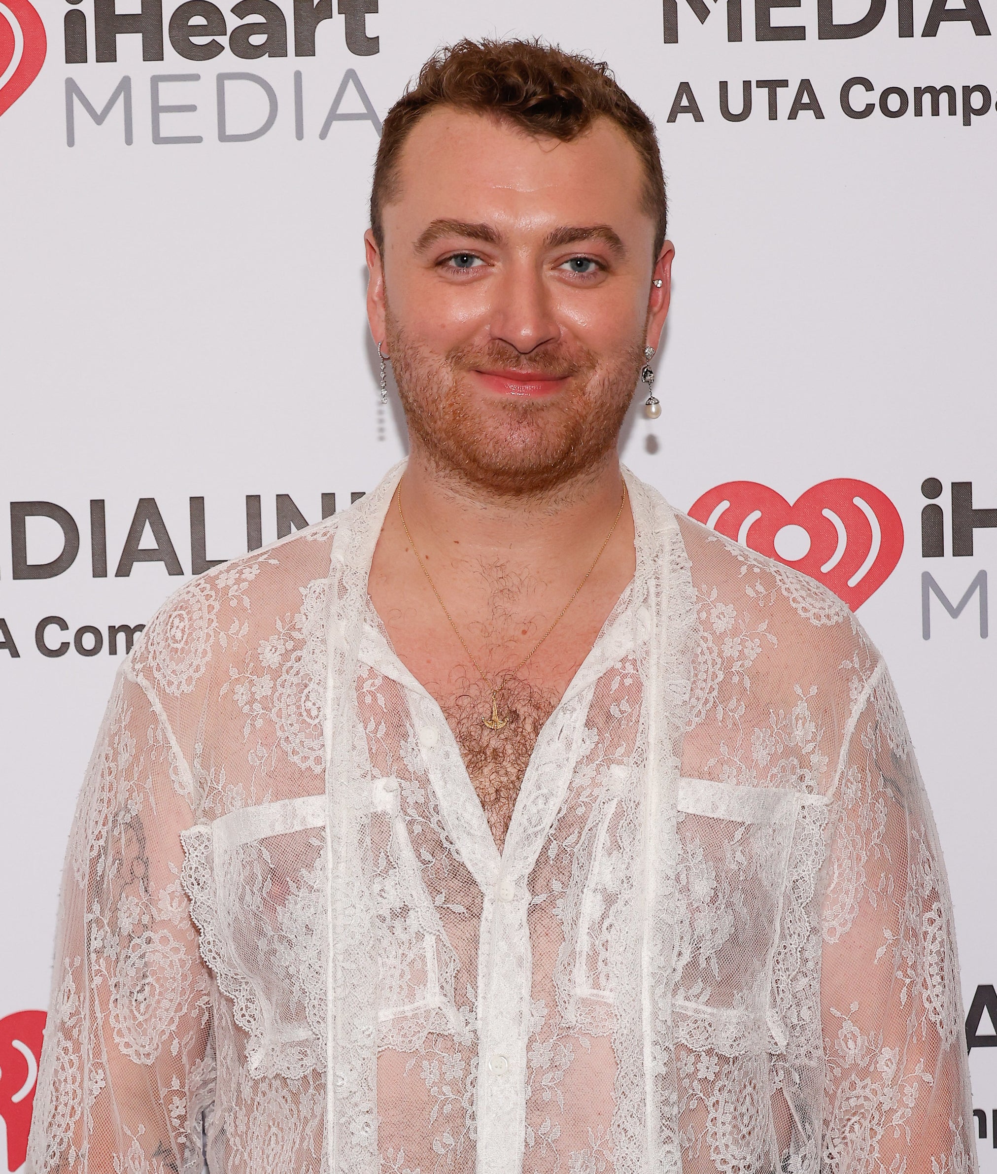 close up of Sam in a sheer lace top smiling