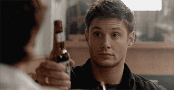 GIF of Dean from Supernatural drinking a beer from a bottle