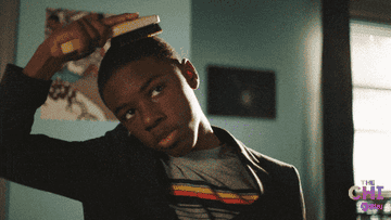GIF of Kevin from The Chi combing his hair