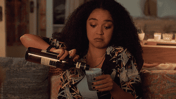 GIF woman pouring a big cup of wine and offering it