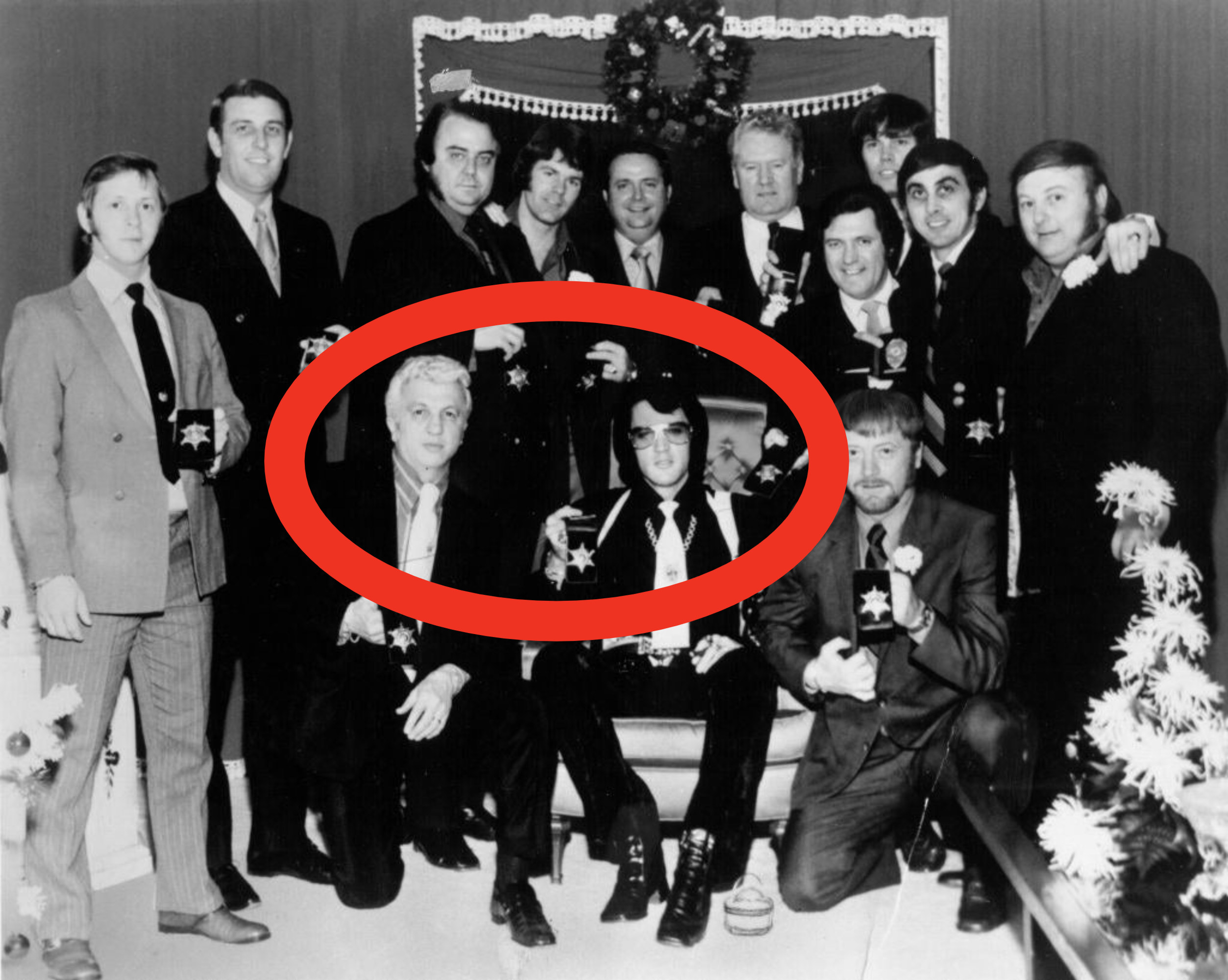 A photo of a large group of people, with a circle around the two in the center, Elvis and Dr. Nick